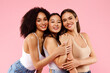 © Prostock-studio - Diverse beauty. Portrait of happy black, asian and caucasian ladies posing and smiling at camera over pink background