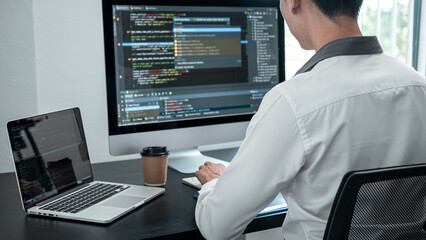 Male programmer working on website project in software development on the desktop computer and making coding and typing data code password security
