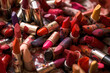 Plenty of lipsticks, new and used spread on a tabletop in a clutter or mess. Beauty and fashion industry consumerism conceptual image. Generative AI