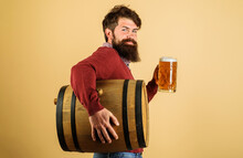 Beer Time. Smiling Man With Glass Of Beer And Wooden Barrel With Craft Beer. Oktoberfest Festival. Attractive Bearded Brewer With Wooden Barrel And Mug Of Beer. Holiday, Drinks, Alcohol And Leisure.