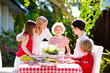 © famveldman - Family eating outdoor. Garden summer fun.