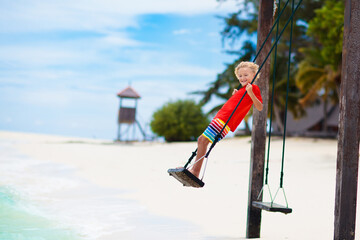 Wall Mural - Child on beach swing. Summer vacation.