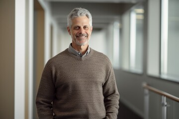 Poster - Portrait of senior man standing in corridor of hospital smiling at camera