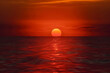 A red sun setting with the ocean in the background, in the style of photorealistic fantasies, astronomy, seascapes wallpaper, heatwave. Generative Ai.