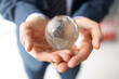 © megaflopp - Man in business suit holds glass globe with continents