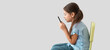 © Pixel-Shot - Little girl with bad posture using mobile phone on light background