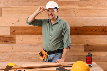 Canvas Print - Mature carpenter at table near wooden wall