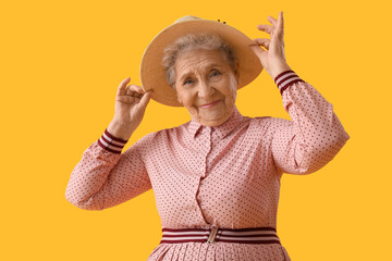 Poster - Senior woman in hat on yellow background