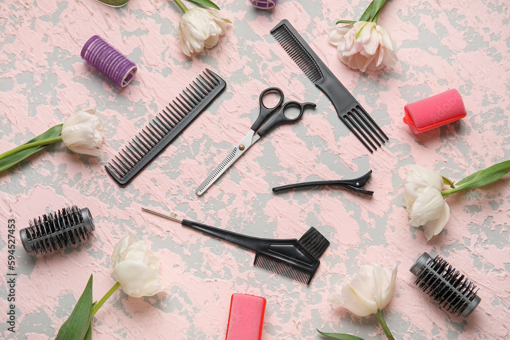 Composition with hairdresser tools and tulip flowers on pink table