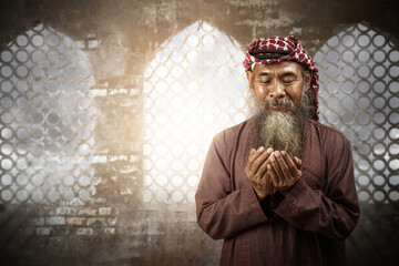 Poster - Muslim man with a beard wearing keffiyeh with agal in praying while raised hands