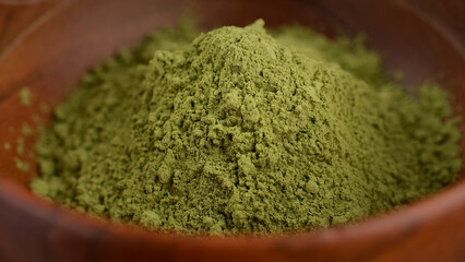 Poster - Heap of Matcha green tea powder in wooden bowl. Healthy drinks concept