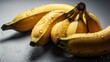 Spotted banana on gray background with water drops on a white background, top view