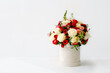 Bouquet of beautiful flowers decorated in round box on light background