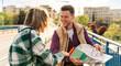 © DusanJelicic - young tourists smile as they cross the bridge and use the map, trying to get back on track