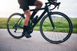 © Azeemud-Deen Jacobs/peopleimages.com - Closeup, legs and athlete on bicycle outdoor for exercise, training and triathlon sports. Person, bike and cycling on road for freedom, cardio fitness and performance with speed, power and transport