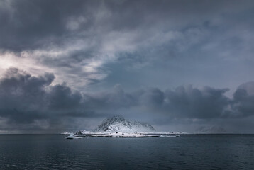 Wall Mural - a snow covered mountain and icebergs rising from the arctic sea in svalbard, arctic circle, with dar