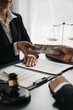 © Phimwilai - Businessman, investor offering bribe Handing money to a female lawyer or legal counsel to help with a lawsuit, signing documents. business contract, law in court Illegal fraud bribery concept.