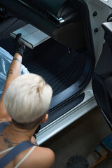 Wall Mural - Photo of Caucasian woman employee fixing car