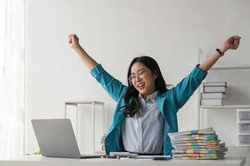 Wall Mural - Young happy business woman worker or feeling excited winning online looking at laptop celebrating professional achievement, getting hired or approved at work