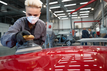 Wall Mural - Woman polishing car with power buffer machine in service center