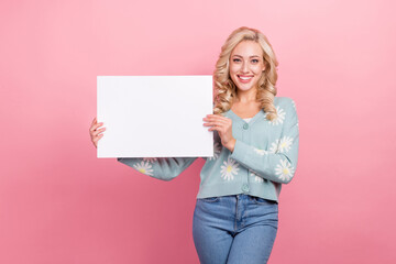 Sticker - Photo of positive nice girl toothy smile hands hold paper empty space blank isolated on pink color background