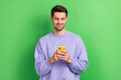 © deagreez - Portrait of positive blogger man hold use telephone chatting communicate isolated on green color background