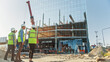 © Gorodenkoff - Real Estate Project Construction Site with Architectural Engineer, Investor and Worker Finish Industrial Building Development by Using 3D VFX Graphics. Futuristic Concept of Buildings Development