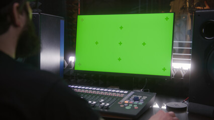 Male singer records song in soundproof room. Sound engineer uses control mixing surface. Computer screen shows DAW software interface and tools for creating music. Sound recording studio. Green screen