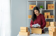 © crizzystudio - small business startup images SME business owner, female entrepreneur packing shirts , Shirts for work to prepare packs sent to customers via express delivery companies, SME business concepts online.