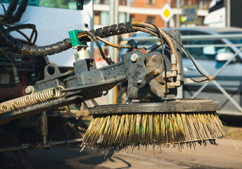 Close-up street sweeper machine cleaning. Concept clean streets from debris. Detail of a road sweeper cleaning the streets. The brush disc of a sweeper truck. 