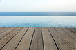 bordo in legno di una piscina che si proietta a strapiombi sul mare