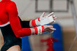 close-up hands female gymnast in gymnastics grips in gym chalk, uneven bars performing