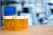 Many orange empty medicine bottles over a table in a laboratory, shortage concept with copy space