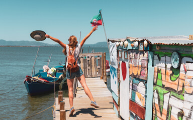 Carrasqueira pier in Portugal-ancient wooden pier with happy woman tourist traveling in Europa