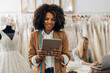 © cherryandbees - A beautiful multiracial woman looks at the tablet. She works in a bridal salon.