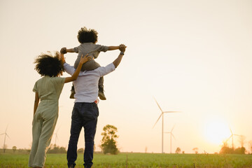 african american family in the community with wind generators turbines, wind turbines are alternativ