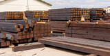 Fototapeta  - stacked piles of new railroad ties also called railway sleepers with anti-split plates on the ends