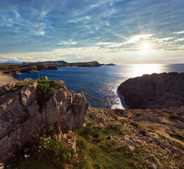 Spring evening Atlantic Ocean coastline landscape with sun reflection on water surface (Cantabria, Spain).