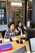 © Wavebreak Media - Happy diverse female creatives at computer, making video call, waving in casual office, copy space