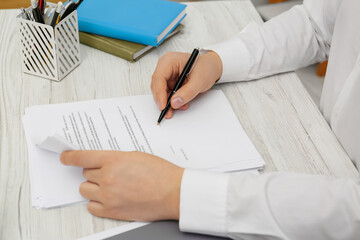 Sticker - Man signing document at wooden table, closeup