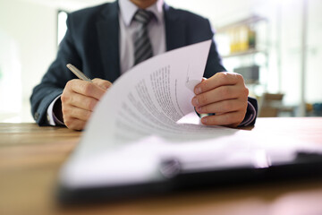 Wall Mural - Businessman flips page of contract signing after reading