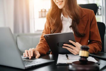 justice and law concept.male judge in a courtroom the gavel, working with smart phone and laptop and