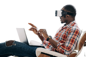 african american man wearing virtual reality glasses works in cyberspace at laptop, sitting in chair