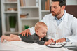 © standret - With stethoscope. Doctor with little baby is working in the cabinet