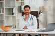 © standret - In white coat, sitting. Doctor in formal clothes is working in the cabinet