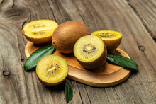 Halved Ripe Yellow Kiwi Fruit On A Wooden Background. Long Banner Format. Top View