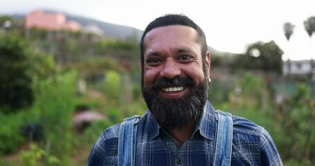 Poster - Indian man smiling on camera while working at his organic vegetables garden outdoor - Local food and sustainability concept