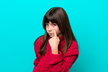 Wall Mural - Little caucasian girl isolated on blue background showing something