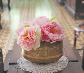 Wall Mural - close up brass vintage vase with flowers on wooden table.
