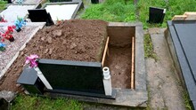 A Freshly Dug Grave In The Cemetery. Funeral Preparation. Open Grave.